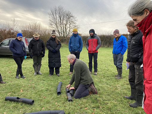 Volunteers looking at a tunnel in a field